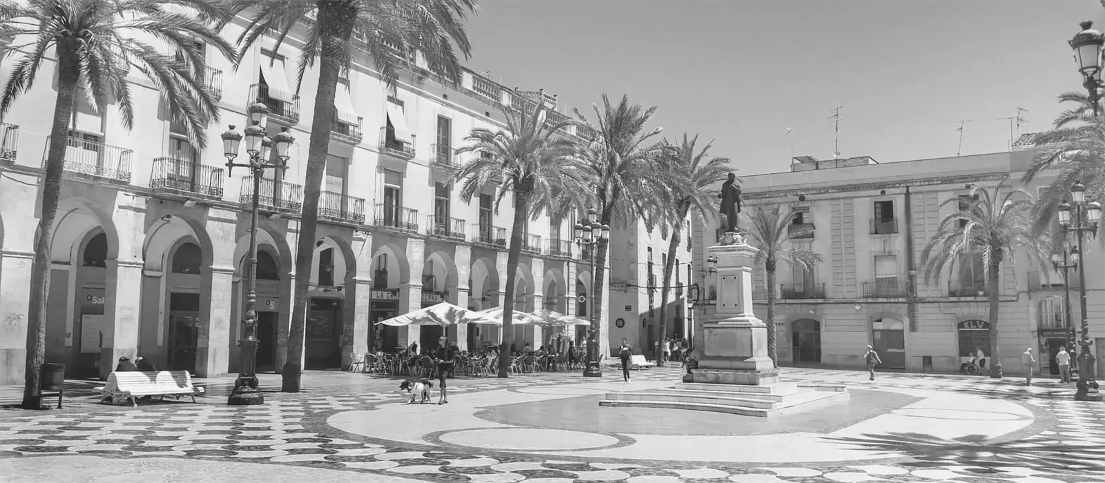 Plaça de la Vila de Vilanova i la Geltrú, amb palmeres i porxos, en blanc i negre